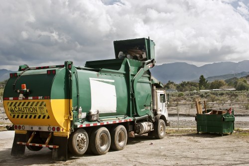 Workers wearing PPE handling a skip